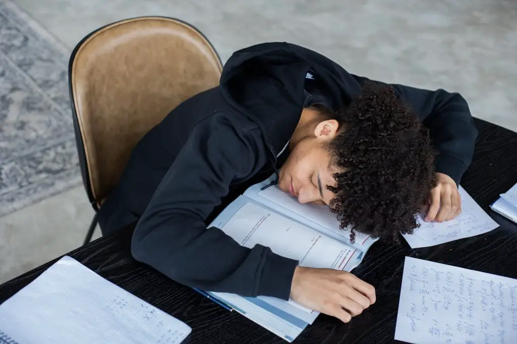 student resting on study table - featured image