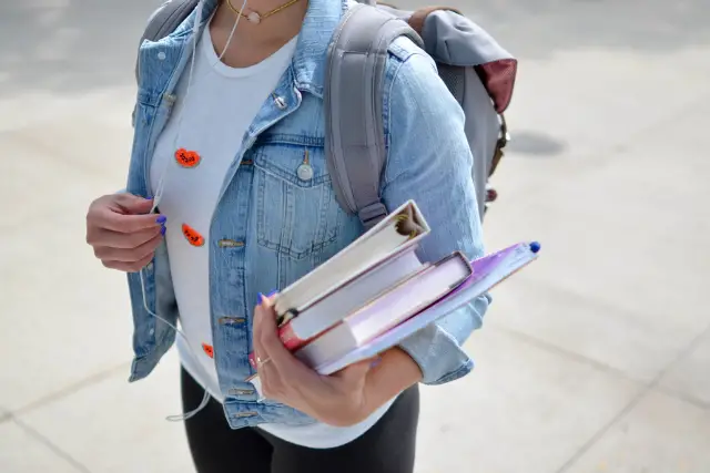 college student carrying books - featured image